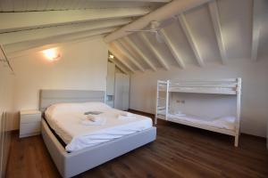 a bedroom with two bunk beds and wooden floors at Villa Betty in San Siro