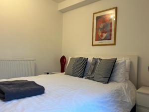 a bedroom with a large white bed with pillows at Lovely Serviced Apartment, Free Parking, Oxford in Oxford