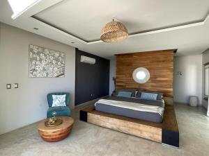 a bedroom with a bed and a blue chair at Luxury Palms Puerto Arista in Puerto Arista