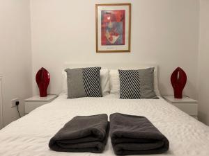 a bedroom with a bed with two towels on it at Lovely Serviced Apartment, Free Parking, Oxford in Oxford
