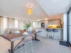 a kitchen and living room with a wooden table and chairs at The Bungalow in Rushton Spencer