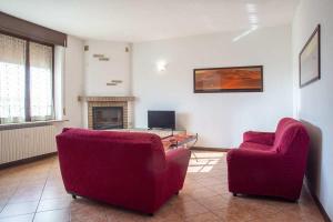 a living room with two red chairs and a table at Agriturismo Gaspari Farm in Volta Mantovana
