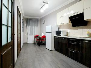 uma cozinha com electrodomésticos brancos e uma mesa com cadeiras vermelhas em 2 комнатная 3-я Слободская и Кузнецкая em Nikolayev