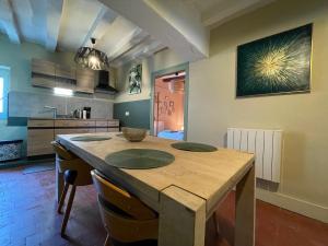 a kitchen with a wooden table in a room at Le Doux Douillet Beauval à 5mn du Zoo - Gite Familial en Hypercentre de Saint-Aignan in Saint-Aignan