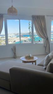 un soggiorno con divano e 2 finestre di Dar Lahlou a Tangeri