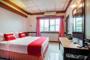 1 dormitorio con 1 cama y escritorio con ordenador en OYO 629 Chaytalay Palace Hotel, en Nathon