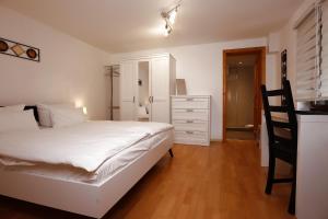 Haus Blattert - Neuglashütten في فيلدبرج: غرفة نوم بسرير ابيض وخزانة
