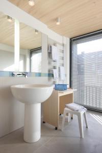 a bathroom with a sink and a desk and a chair at Hotel Niedersachsen in Westerland