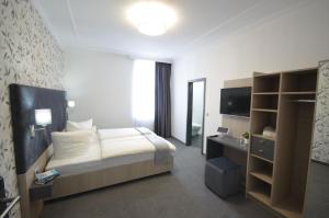 a hotel room with a bed and a television at N9 Hotel Nürnberg-City in Nuremberg