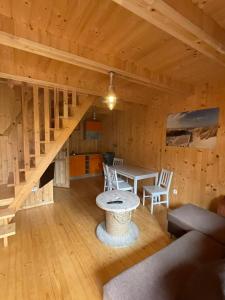 una habitación con una mesa y una escalera en una cabaña en Sarbinowo SOMMER, en Sarbinowo