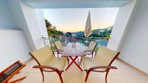 a table and chairs on a balcony with a view at Mediterraneo Resort in Parga