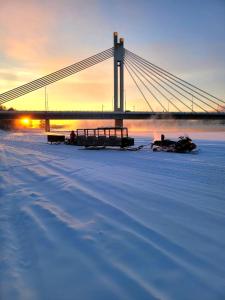 a bridge over a snowy field with a bridge in the background at Villa Koivikko in Rovaniemi