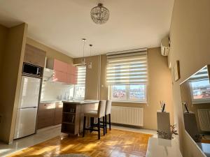 een keuken met een tafel en stoelen in een kamer bij Trident Apartments 3 in Niš