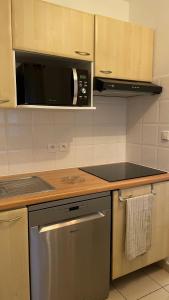 a kitchen with a stove and a microwave at Chalet paisible à la plage, piscine et tennis in Ondres