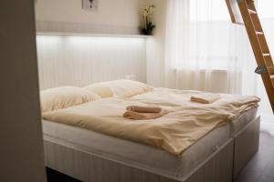 Una cama con dos toallas en una habitación en U divokej včely, en Ižipovce