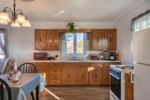uma cozinha com armários de madeira e um forno com placa de fogão em Oakbend Cottage em Newville