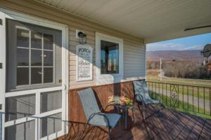 eine Veranda mit zwei Stühlen und ein Schild drauf in der Unterkunft Oakbend Cottage in Newville