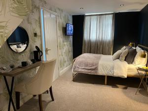 a bedroom with a bed and a desk and a mirror at The Old Farmhouse in Bristol