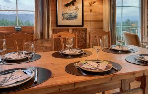 einen Holztisch mit Tellern und Weingläsern darauf in der Unterkunft 3 Bedroom Gorgeous Home In Bykle in Bykle