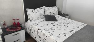 a bed with a black and white comforter and pillows at Pensiunea Izabel in Lacu Rosu