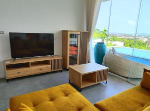 sala de estar con TV y sofá en Villa Gratia Alba en Nathon Bay