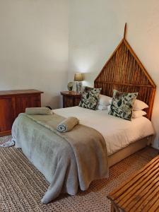 a bedroom with a large bed with a large wooden headboard at Dar Amane Guest House in Graskop