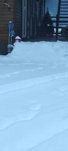 a pile of snow in front of a house at Pensiunea Izabel in Lacu Rosu