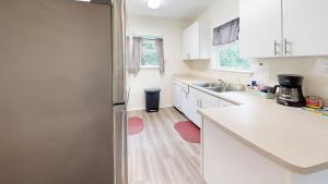 a kitchen with white cabinets and a stainless steel refrigerator at Air Haus in Fourth Crossing
