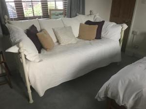 a white bed with pillows on it in a room at Wrens Nest in Axminster