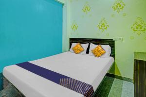 a bedroom with a bed with blue and yellow pillows at SPOT ON 81083 Sky Villa Hotel in Patna
