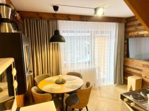 a kitchen with a table and chairs in a room at Modrzew in Zakopane