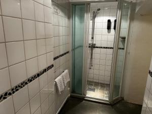 a bathroom with a shower with a glass door at Hotel Tre Små Rum in Stockholm