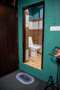 een badkamer met een toilet en een grote spiegel bij Family Homestay Darjeeling in Darjeeling