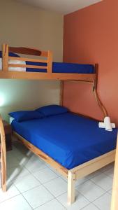 a bedroom with two bunk beds with blue sheets at Riveri Salinas host in Salinas