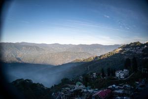 uma vista para um vale com uma cidade e montanhas em Family Homestay Darjeeling em Darjeeling