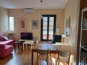 een woonkamer met een tafel en een bank bij APARTAMENT CASA CORDERET in Tarragona