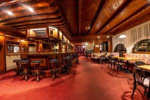 Hotel Brunella في فاندنس: وجود بار بالطاولات والكراسي في المطعم