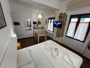a room with a white bed and a kitchen at Aigua in Alghero