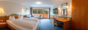 una camera d'albergo con letto e scrivania di Hotel Brunella a Vandans