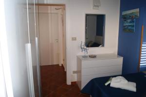 een slaapkamer met een witte dressoir en een spiegel bij Villa Milena in Marzamemi