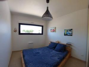 sypialnia z łóżkiem z niebieskimi prześcieradłami i oknem w obiekcie Maison rénovée 4 pièces au cœur de St Pierre d'Oléron avec terrasse, proche commerces, 6 couchages - FR-1-246A-137 w mieście Saint-Pierre-dʼOléron