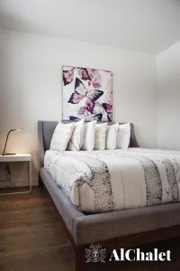 uma cama com almofadas e um quadro na parede em Beaulieu - vue boisé spa sauna em Pont-Rouge