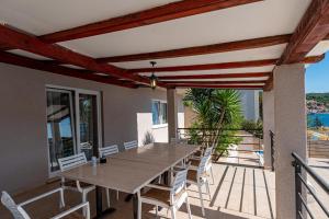 a dining room with a table and chairs on a balcony at Beachfront villa with private pool in Vela Luka in Vela Luka