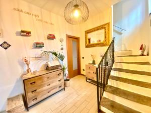 a room with a staircase and a dresser and a mirror at La Casa Del Poeta in Dervio