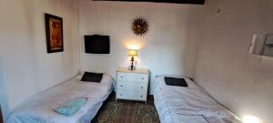 Torrepalma的住宿－Estudio 1 Hacienda Torrepalma，一间卧室配有两张床、一个梳妆台和电视。