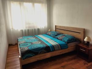 sypialnia z łóżkiem z niebieską kołdrą i oknem w obiekcie Apartmány u Jiroušů w Rokitnicach nad Izerą +37 zdjęć