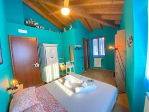 a bedroom with blue walls and a bed with white sheets at La Casa Del Poeta in Dervio