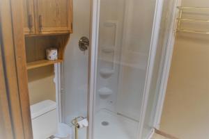 a shower with a glass door in a bathroom at River Hideout: One Bedroom Duplex Cottage ON THE RIVER!! in Ruidoso +16 photos