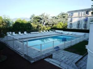 a swimming pool with chairs and a fence at Residence Albion - Agréable petit studio offrant une belle vue dégagée ! MAE-7564 in Aix-les-Bains