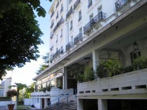 um grande edifício branco com escadas em frente em Residence Albion - Studio pour 2 Personnes 564 em Aix-les-Bains